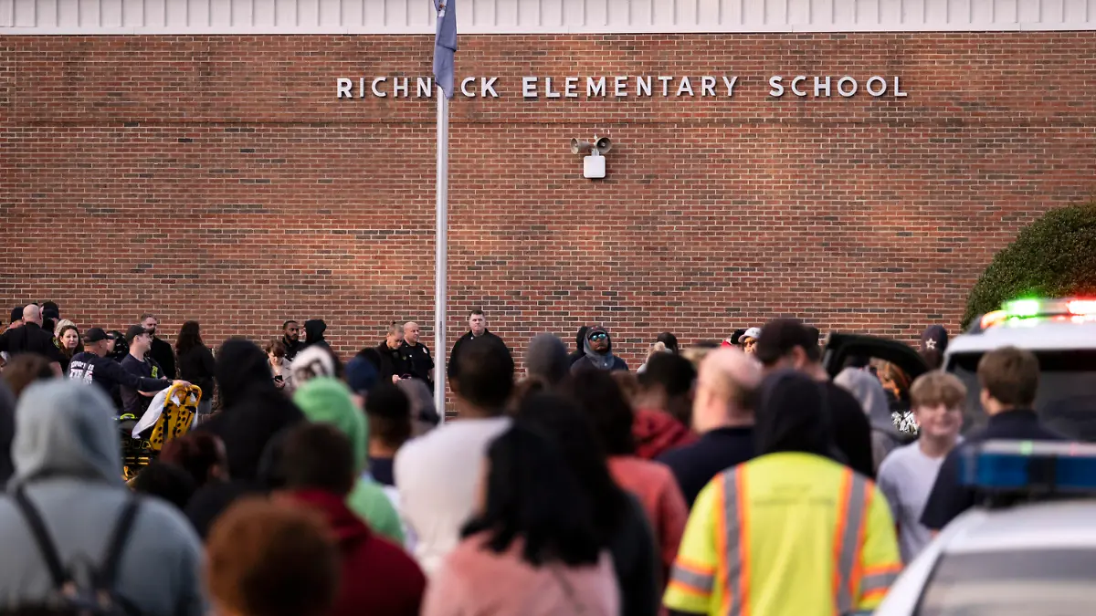 FILE - Students and police gather outside of Richneck Elementary School after a shooting, Jan. 6, 2023 in Newport News, Va. A Virginia teacher who was shot and seriously wounded by her 6-year-old student filed a lawsuit Monday, April 3, 2023, seeking $40 million in damages from school officials, accusing them of gross negligence and of ignoring multiple warnings the day of the shooting that the boy was armed and in a “violent mood.” (Billy Schuerman/The Virginian-Pilot via AP, File)