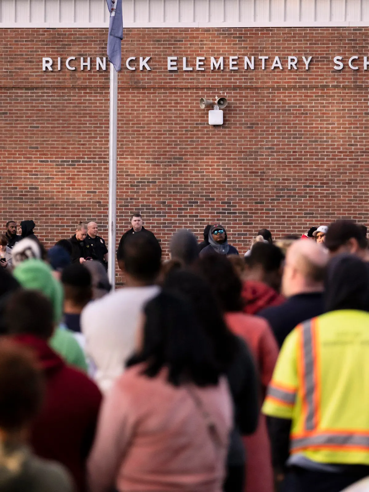 FILE - Students and police gather outside of Richneck Elementary School after a shooting, Jan. 6, 2023 in Newport News, Va. A Virginia teacher who was shot and seriously wounded by her 6-year-old student filed a lawsuit Monday, April 3, 2023, seeking $40 million in damages from school officials, accusing them of gross negligence and of ignoring multiple warnings the day of the shooting that the boy was armed and in a “violent mood.” (Billy Schuerman/The Virginian-Pilot via AP, File)