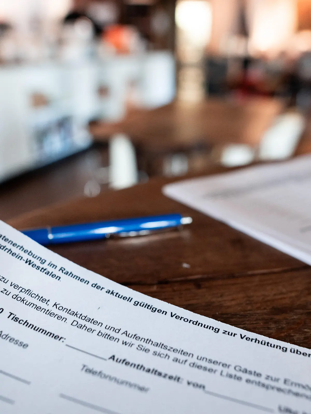 30.09.2020, Nordrhein-Westfalen, Dortmund: Ein Zettel für die Kontaktdaten von Gästen liegt in einem Restaurant in Dortmund. Für falsche Angaben zur Person auf den Kontaktlisten in Restaurants oder Gaststätten verhängt das Land Nordrhein-Westfalen künftig ein Bußgeld in Höhe von 250 Euro. Das teilte NRW-Gesundheitsminister Laumann (CDU) am Mittwoch in Düsseldorf mit. Foto: Fabian Strauch/dpa +++ dpa-Bildfunk +++