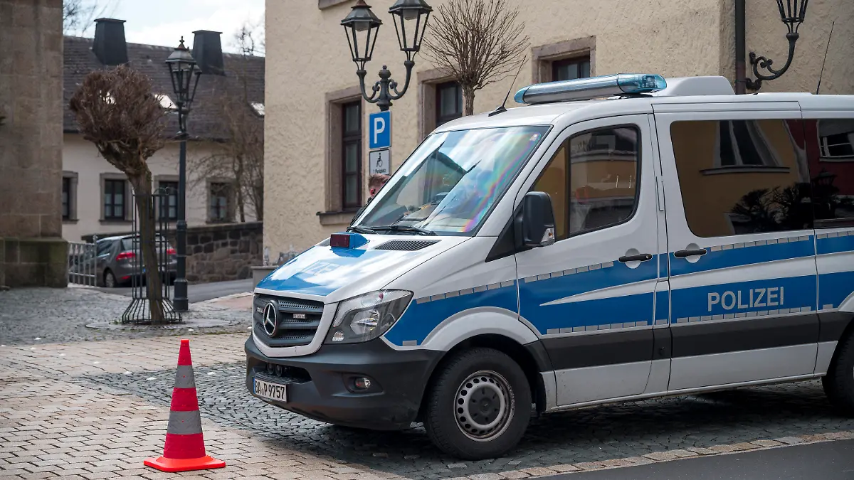 05.04.2023, Bayern, Wunsiedel: Ein Einsatzwagen der Polizei sperrt die Straße zu einem Kinder- und Jugendhilfezentrum ab. In der Einrichtung war am Vortag eine Zehnjährige tot in einem Zimmer gefunden worden. Zwei Jungen im Alter von 11 Jahren und ein 16-Jähriger stehen im Fokus der Ermittler. Foto: Daniel Vogl/dpa +++ dpa-Bildfunk +++