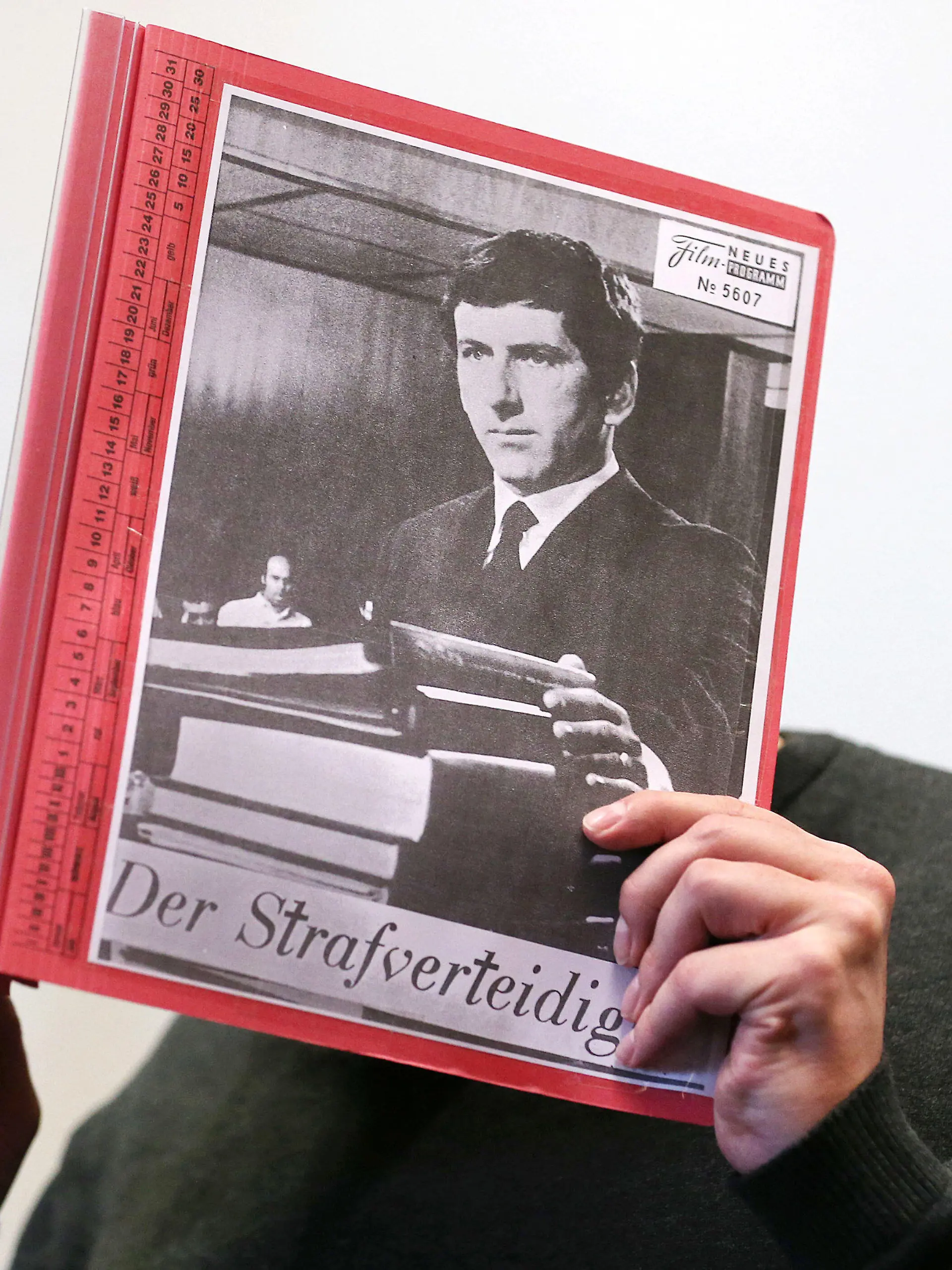 ARCHIV - 17.08.2020, Nordrhein-Westfalen, Köln: Der Angeklagte sitzt zu Beginn eines Prozesstages wegen schweren sexuellen Missbrauchs von Kindern im Gerichtssaal, während er sich eine Mappe mit aufgeklebten Fotos von Filmszenen des Films «Der Strafverteidiger» vor das Gesicht hält. (zu dpa: «Fall Bergisch Gladbach: Angeklagter berichtet über eigenen Missbrauch») Foto: Oliver Berg/dpa - ACHTUNG: Nur zur redaktionellen Verwendung im Zusammenhang mit einer Berichterstattung über den Prozess im Missbrauchsfall Bergisch Gladbach und nur mit vollständiger Nennung des vorstehenden Credits +++ dpa-Bildfunk +++