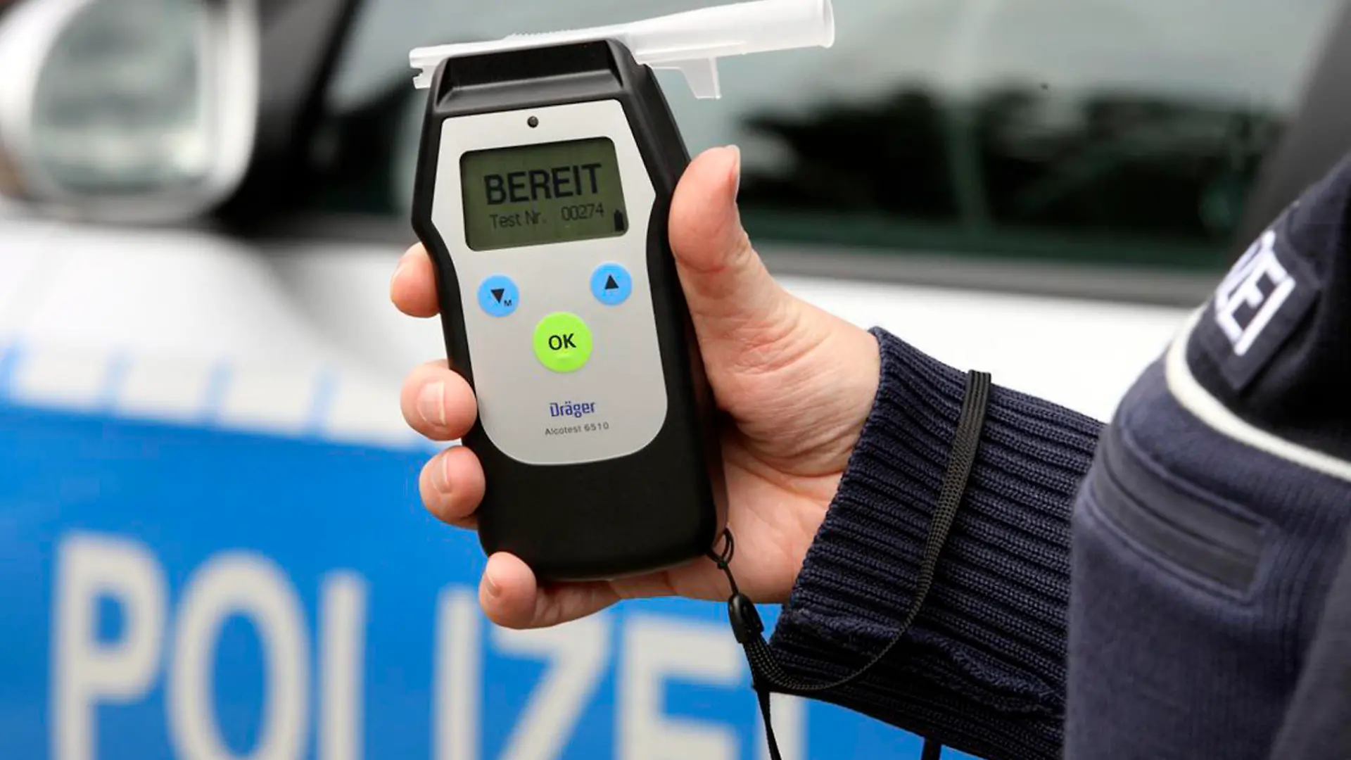 Symbolbild: Polizist hält ein Alkoholmessgerät in der Hand