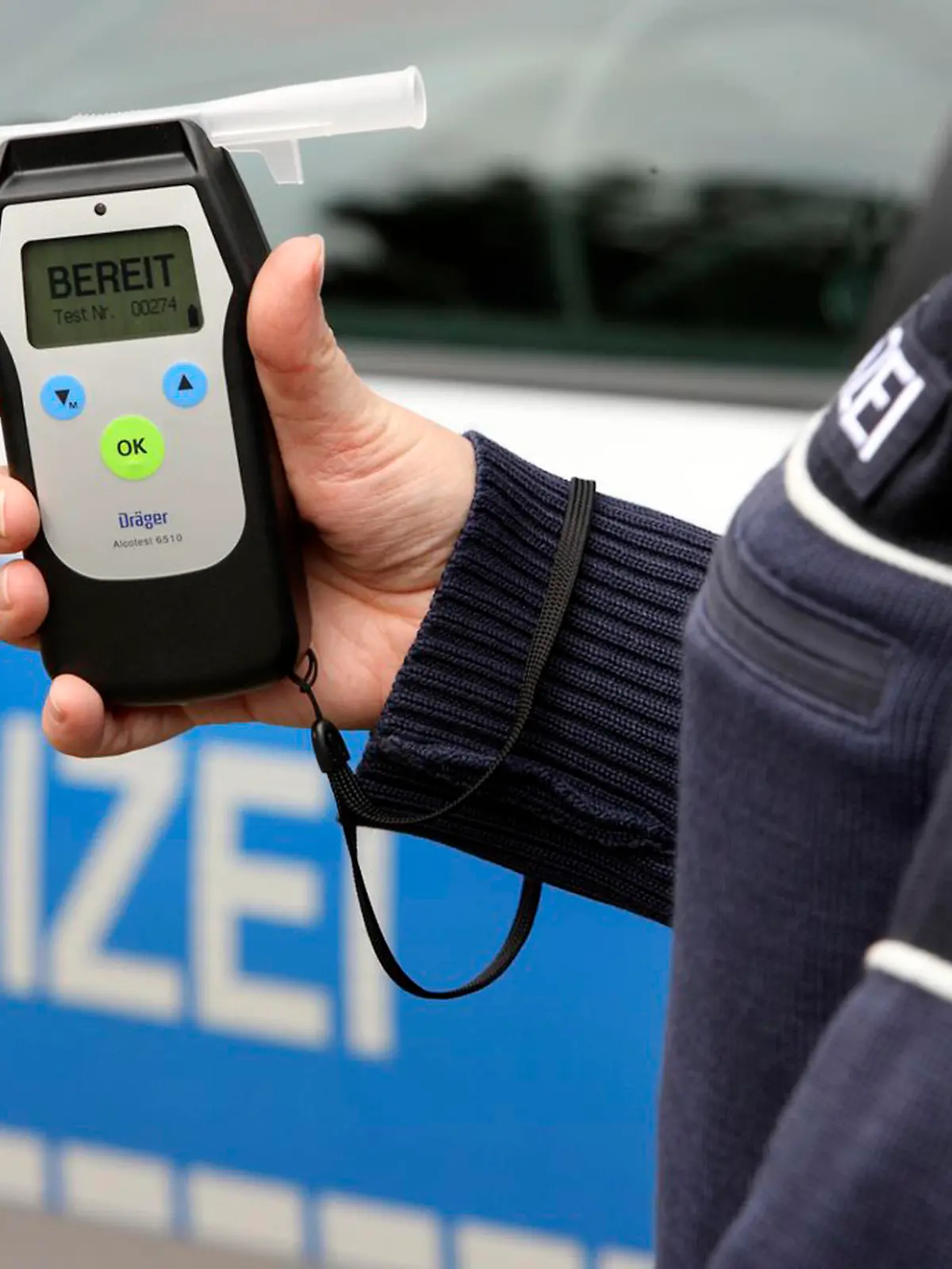 Symbolbild: Polizist hält ein Alkoholmessgerät in der Hand