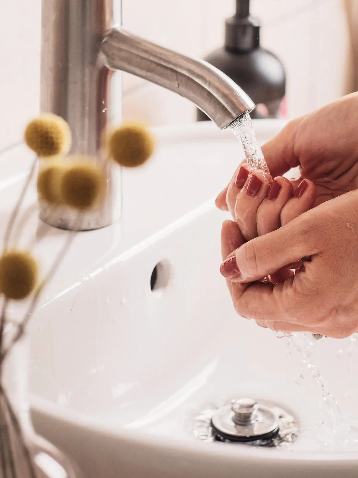 Frau wäscht sich die Hände im Waschbecken
