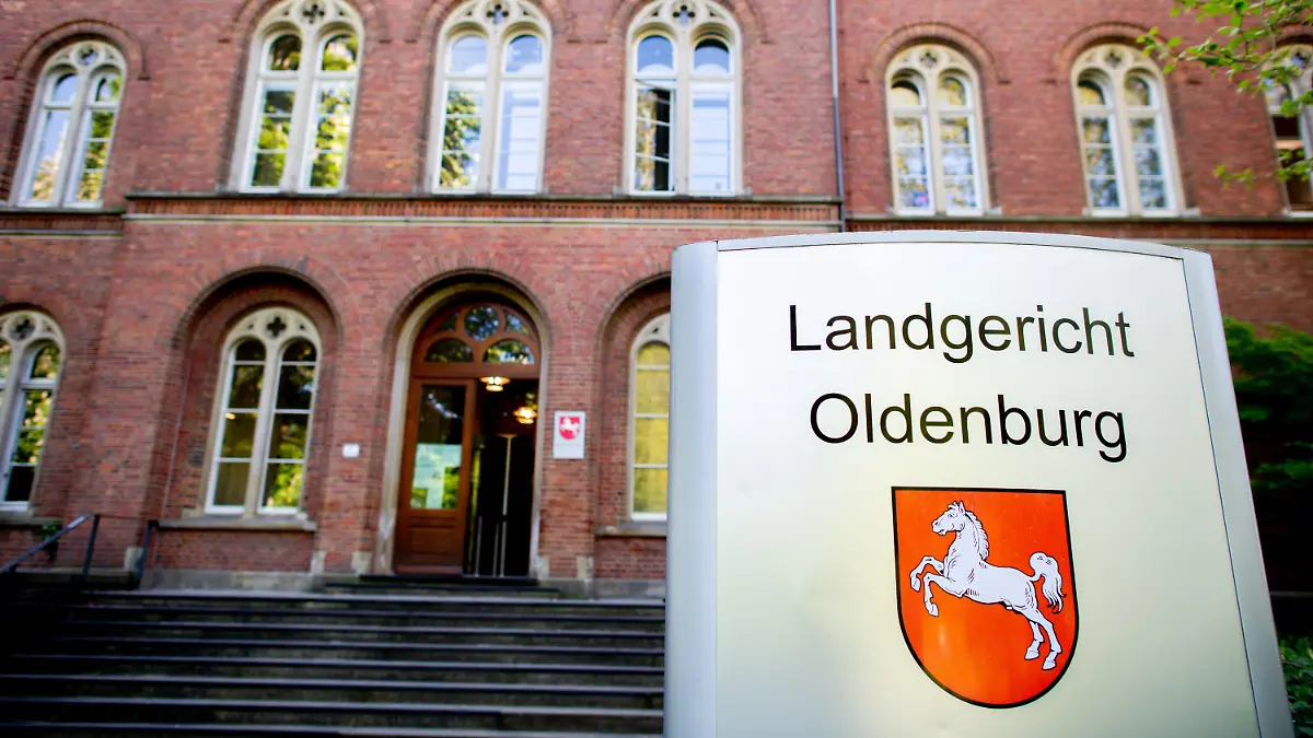 09.05.2022, Niedersachsen, Oldenburg: Ein Schild mit dem niedersächsischen Landeswappen steht vor dem Eingang zum Landgericht Oldenburg, wo ein Prozess wegen zweifachen Mordes fortgesetzt wird. Der angeklagte Mann soll im Oktober 2021 in Delmenhorst zunächst in einer Bar einen vermeintlichen Nebenbuhler erstochen haben. Anschließend verletzte er seine Lebensgefährtin mit einem Messer so stark, dass sie zwei Tage später starb. Foto: Hauke-Christian Dittrich/dpa +++ dpa-Bildfunk +++