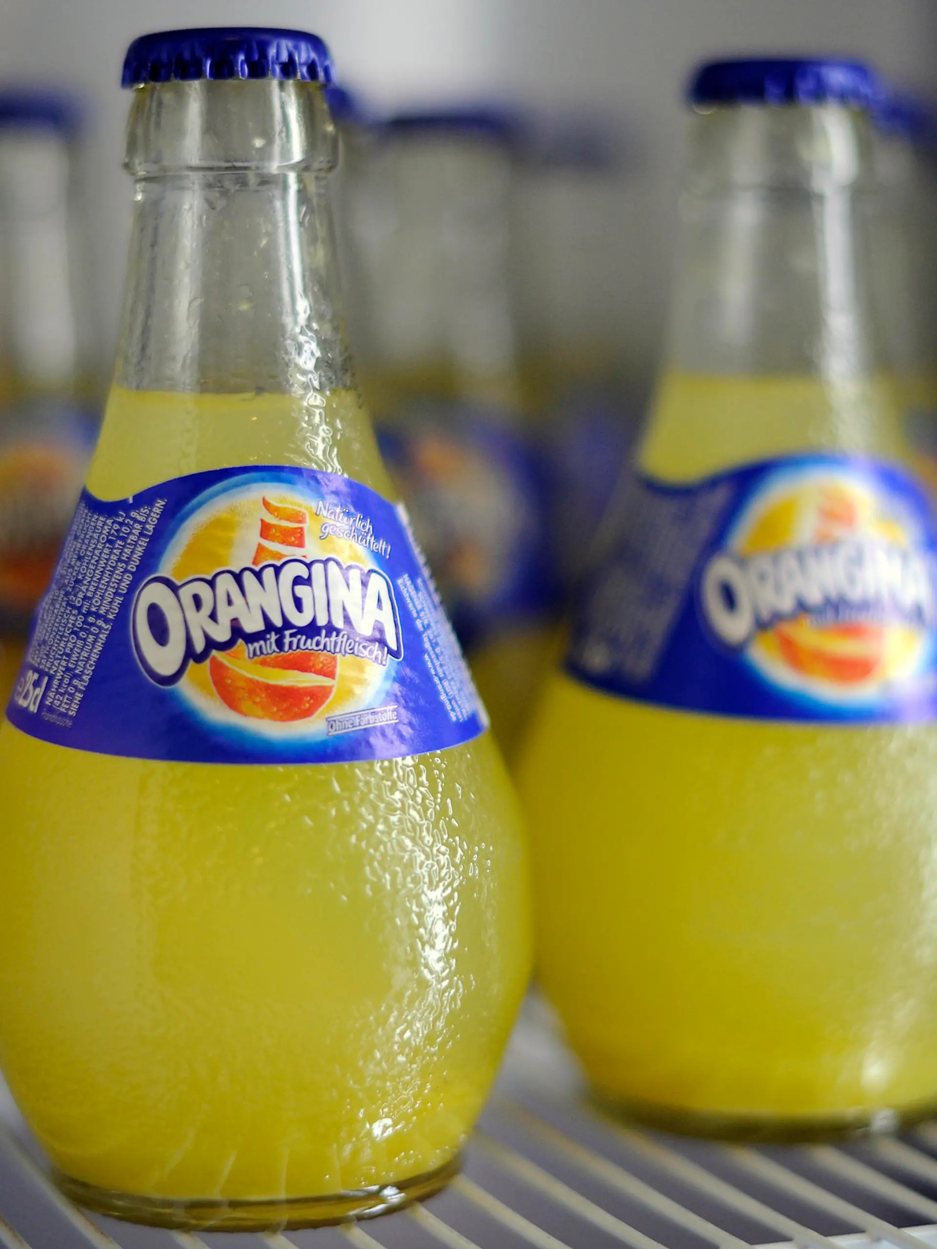 Flaschen der Marke Orangina stehen am Dienstag (24.01.2012) in Düsseldorf vor der Jahres-Pressekonferenz der Krombacher Brauerei in einem Kühlschrank. Der Ausstoß der Krombacher Gruppe legte im abgelaufenen Jahr auf 6,428 Millionen Hektoliter zu. Das ist der bislang höchste je von der Krombacher Gruppe erreichte Ausstoß. Foto: Marius Becker dpa/lnw