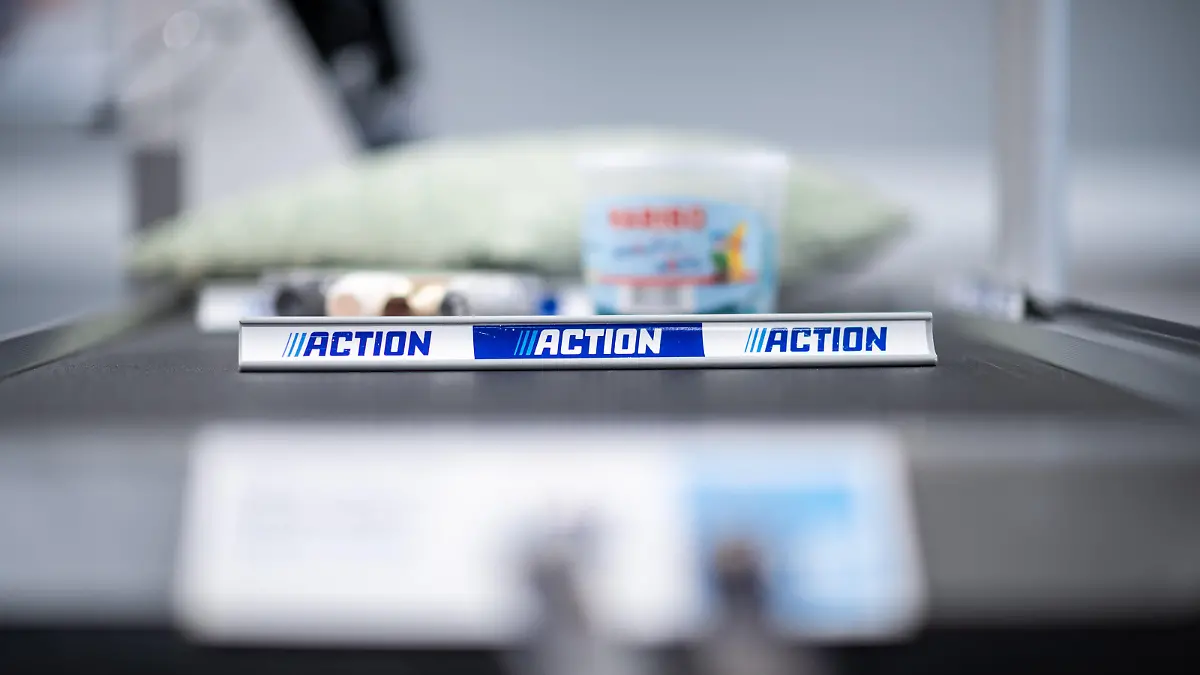 Warentrenner mit dem Logo der Firma „Action“ liegen auf dem Laufband einer Kasse. Der niederländische Billiganbieter betreibt in Deutschland aktuell 379 Filialen, in denen er ein breites Angebot von Dekoartikeln bis zu Nahrungsmitteln, von Mode bis zu Do-it-Yourself-Produkten verkauft. Europaweit sind es mehr als 1500 Geschäfte.