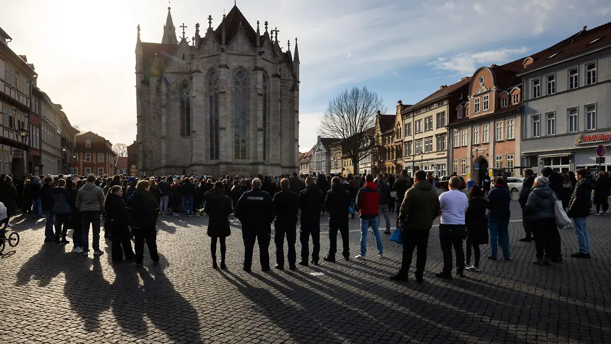 04.04.2023, Thüringen, Mühlhausen: Menschen trauern mit Blumen und Kerzen bei einer Gedenkveranstaltung auf dem Untermarkt um die nach einem Unfall bei Bad Langensalza Verstorbenen. Die Ermittlungen nach dem schweren Unfall am frühen Samstagabend mit sieben Toten in Thüringen halten an. Foto: Michael Reichel/dpa +++ dpa-Bildfunk +++