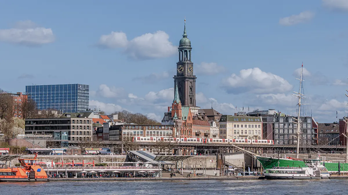 Blick über die Elbe auf die Landungsbrücken mit der Hauptkirche St.Michaelis, umgangssprachlich „Der Michel”, im Hintergrund.