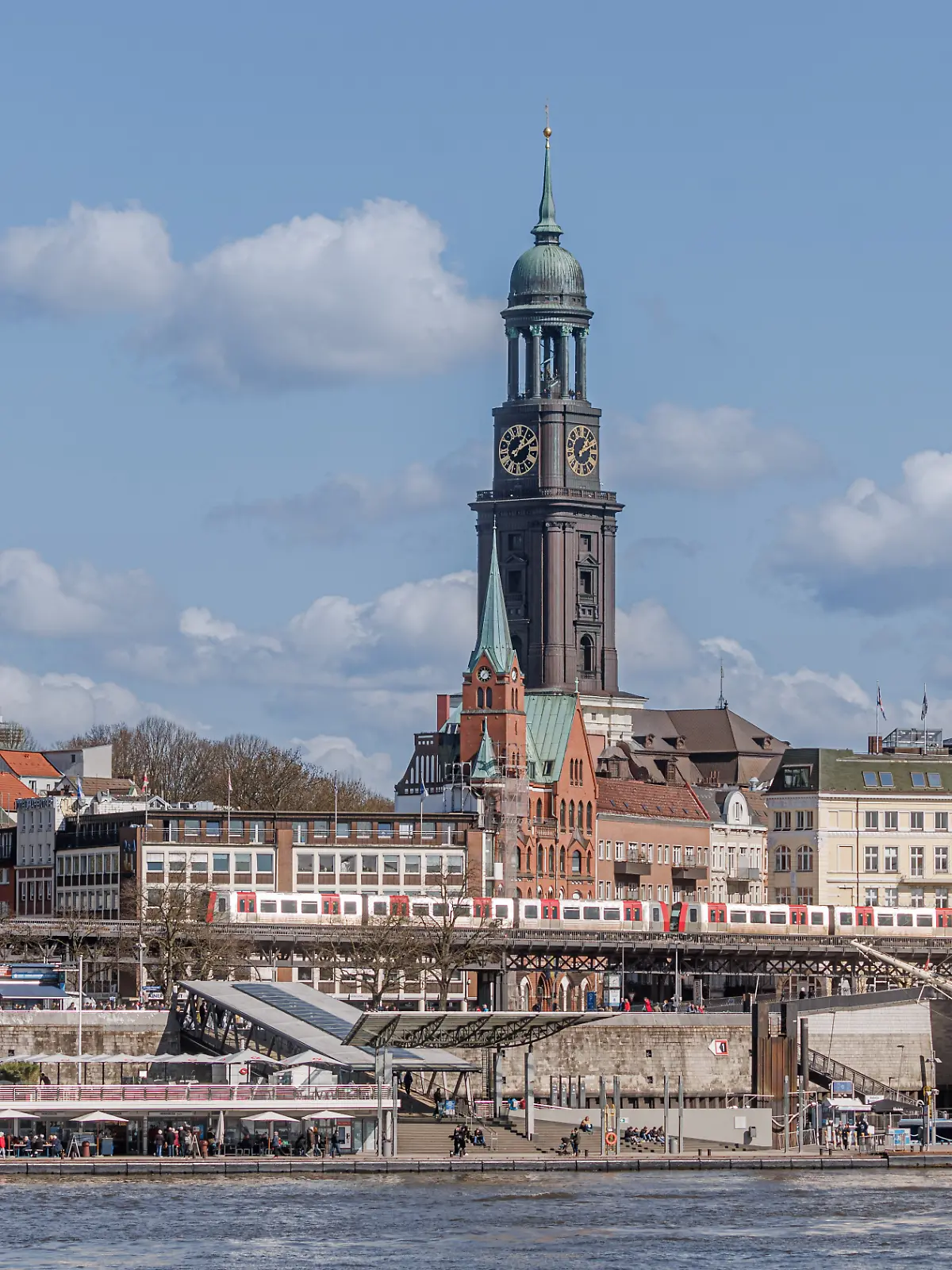 Blick über die Elbe auf die Landungsbrücken mit der Hauptkirche St.Michaelis, umgangssprachlich „Der Michel”, im Hintergrund.