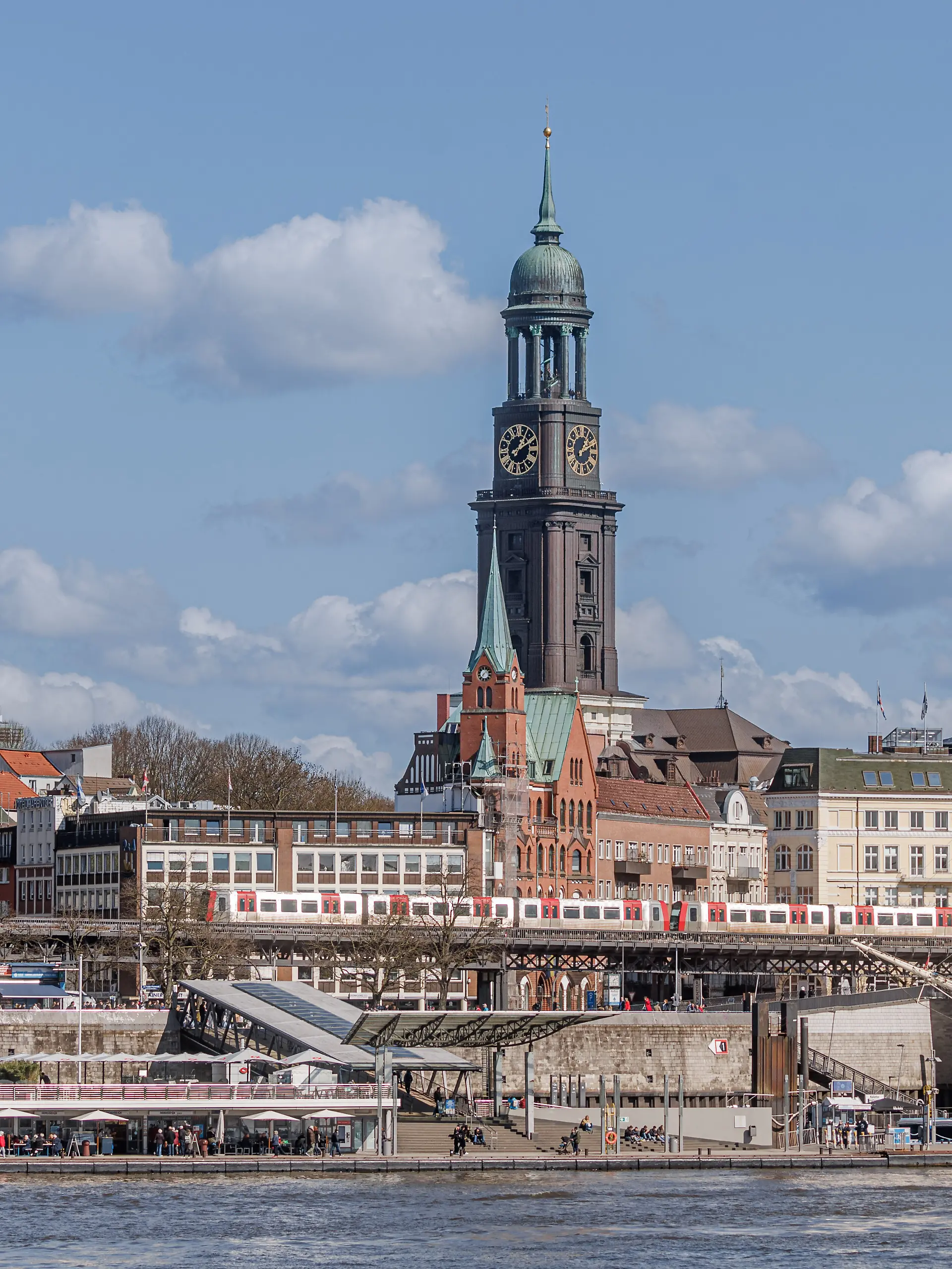 Blick über die Elbe auf die Landungsbrücken mit der Hauptkirche St.Michaelis, umgangssprachlich „Der Michel”, im Hintergrund.