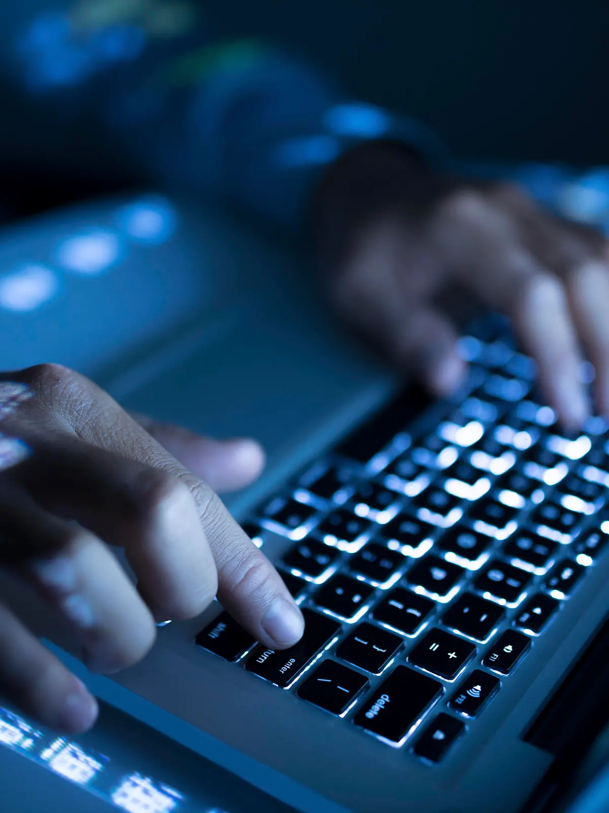 Close-up image of coder typing on computer
