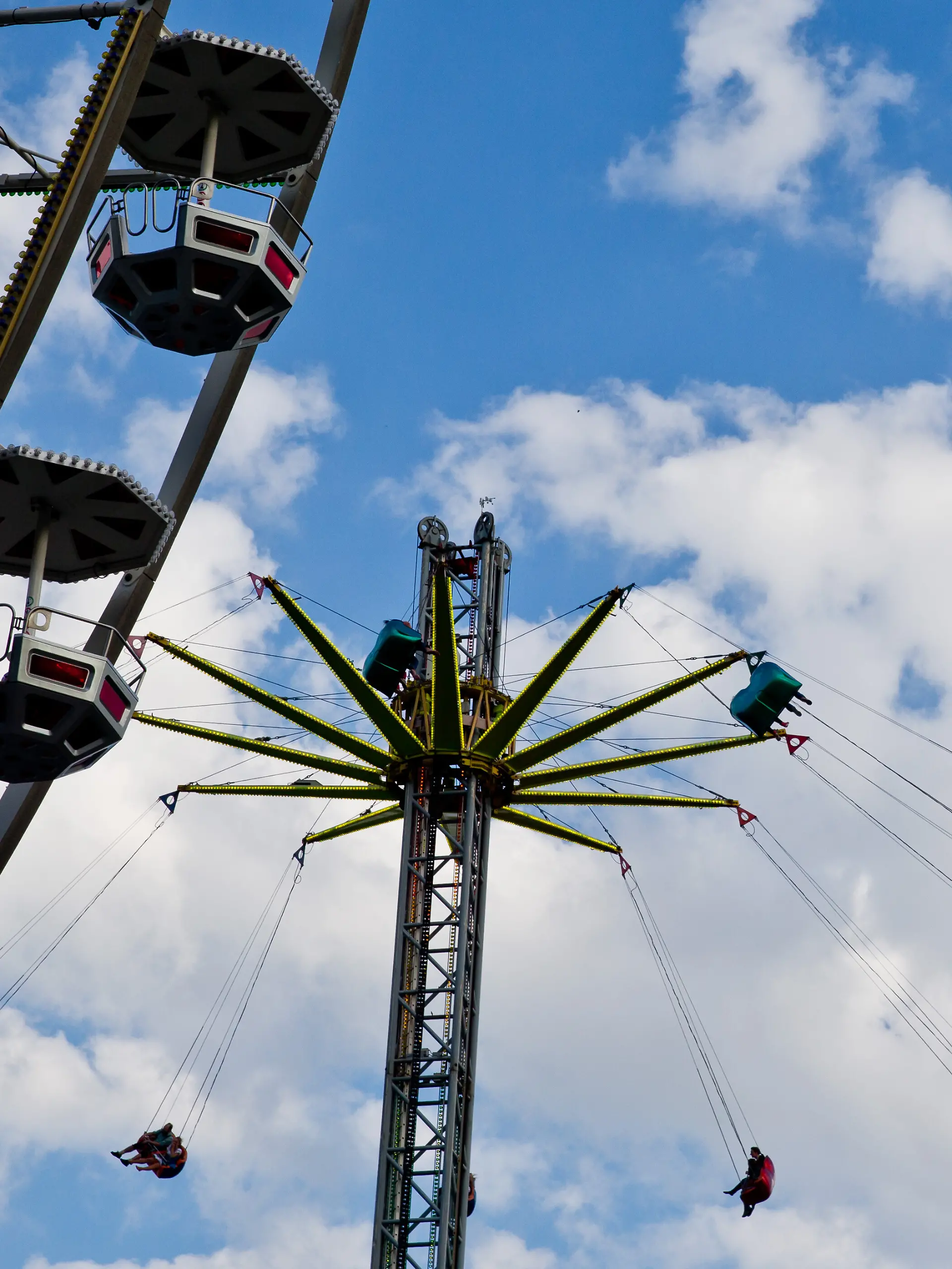 Fahrgäste schweben am 05.06.2014 in Erlangen (Bayern) während der 259. Bergkirchweih neben dem Riesenrad in einem Kettenkarussel. Bis zum 16. Juni erwarten 17 Keller- und Festwirte und etwa 100 Schausteller- und Imbissbetriebe rund eine Million Besucher auf einem der größten Volksfeste Bayerns. Foto: Daniel Karmann/dpa +++ dpa-Bildfunk +++