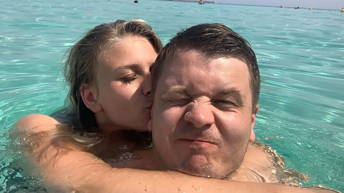 Paar im Meer, Sie küsst ihn auf die Wange