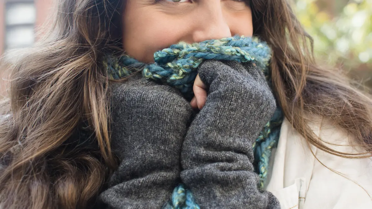 Young woman hiding her face behind scarf Keine Weitergabe an Drittverwerter.