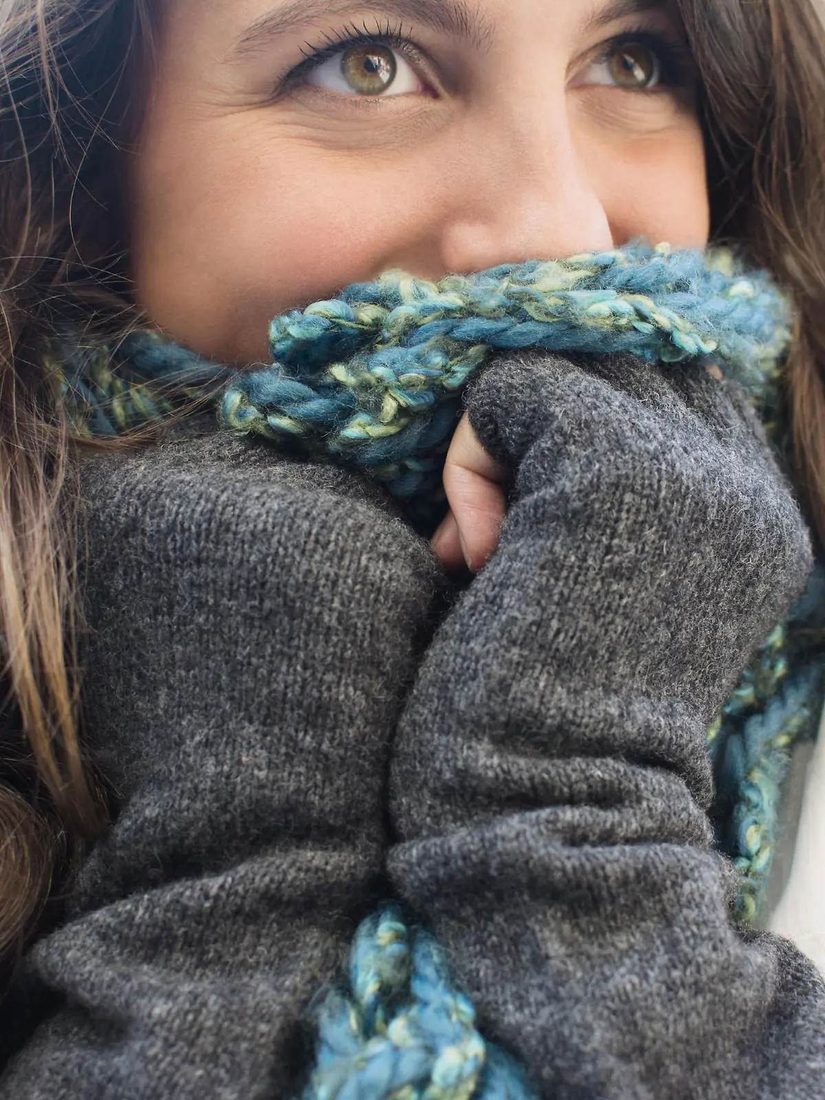 Young woman hiding her face behind scarf Keine Weitergabe an Drittverwerter.