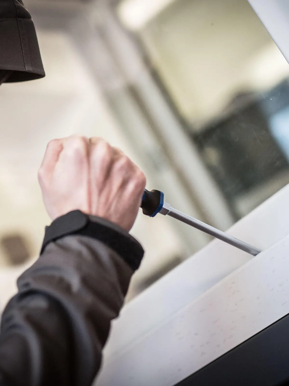ARCHIV - ILLUSTRATION - 10.04.2015, Hessen, Frankfurt: Ein Mann demonstriert in der polizeilichen Beratungsstelle, wie einfach es für einen Einbrecher wäre, mit Hilfe eines stabilen Schraubenziehers ein geschlossenes Fenster von außen zu öffnen. (zu dpa «Mehr Gewalt, mehr Betrug, mehr Drogen: Zahl der Straftaten gestiegen» vom 25.03.2018) Foto: Frank Rumpenhorst/dpa +++ dpa-Bildfunk +++