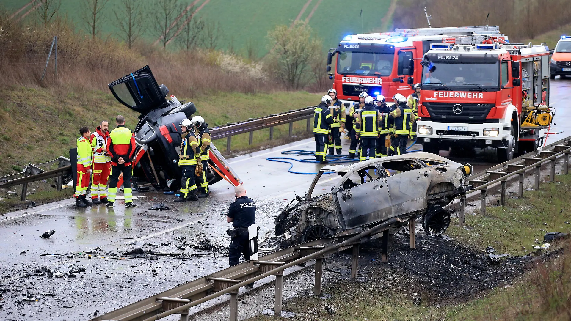 Ein ausgebrannter PKW und ein weiteres verunfalltes Fahrzeug stehen an der Unfallstelle auf der B247 bei Bad Langensalza. Bei einem schweren Verkehrsunfall im Norden Thüringens sind am späten Samstagnachmittag nach Polizeiangaben mehrere Menschen ums Leben gekommen. An dem Unfall waren drei Fahrzeuge beteiligt von denen zwei in Flammen gerieten.