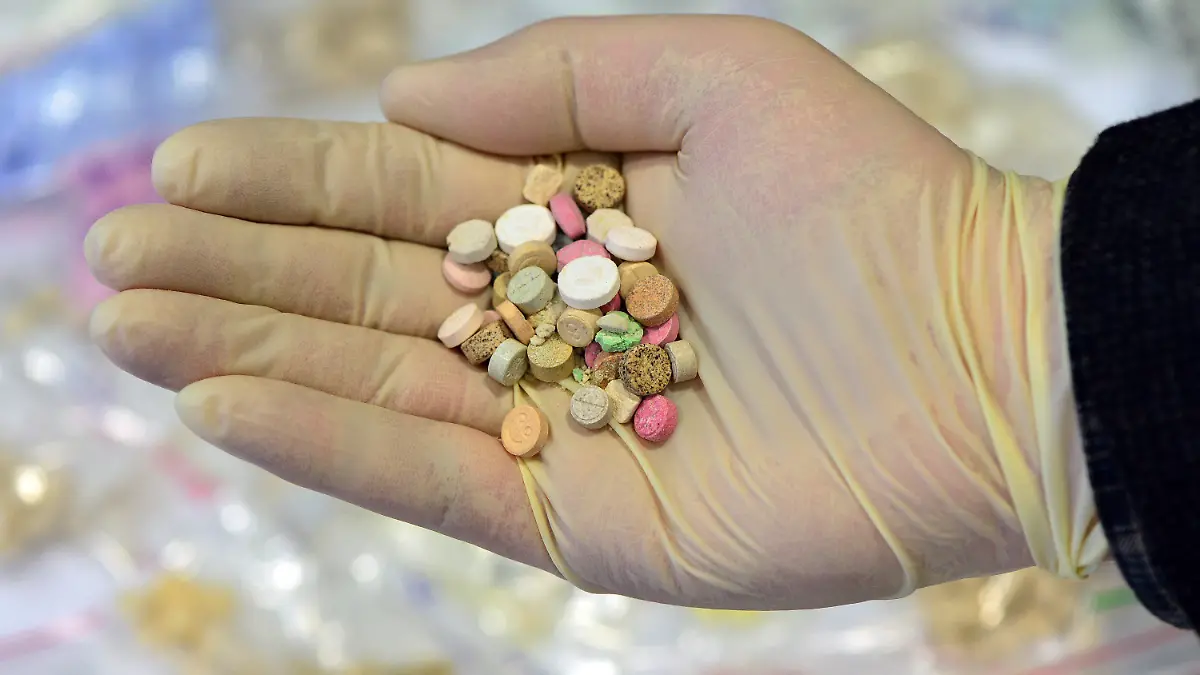 ARCHIV - Ein Ermittler präsentiert am 26.08.2014 im Landeskriminalamt in Erfurt (Thüringen) sichergestellte Ecstasy-Tabletten. In Irland ist der Konsum von Drogen wie Ecstasy, sogenannten Zauberpilzen, Ketamin und anderen Drogen wegen einer Lücke in der Gesetzgebung vorübergehend legal geworden. Foto: Martin Schutt/dpa (zu dpa «Ecstasy und andere Drogen in Irland kurzzeitig legal konsumierbar» vom 10.03.2015) +++(c) dpa - Bildfunk+++