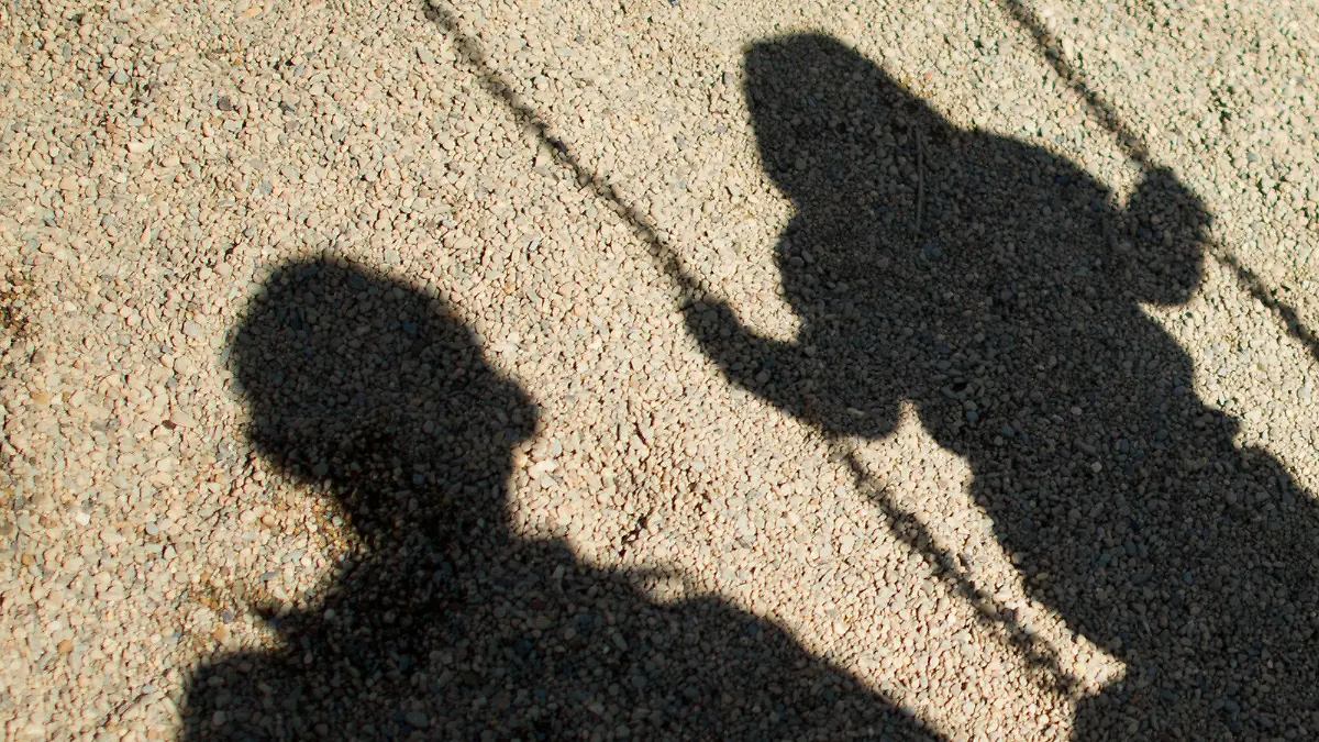 ARCHIV - Der Schatten von einem Mann und einem schaukelnden Kind fallen am 27.08.2014 auf Sand auf einem Spielplatz in Braunschweig (Niedersachsen). Dank der aufsehenerregenden öffentlichen Fahndung mit Missbrauchsfotos eines vierjährigen Mädchens haben die Ermittler einen 24-Jährigen aus dem niedersächsischen Landkreis Wesermarsch festgenommen. (zu dpa «Fahndungserfolg in Missbrauchsfall: 24-jähriger Mann festgenommen» vom 10.10.2017) Foto: Julian Stratenschulte/dpa +++(c) dpa - Bildfunk+++