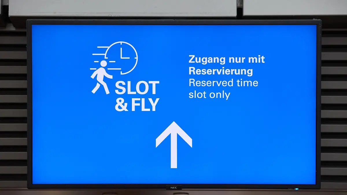 05.04.2023, Hamburg: Ein Screen mit der Aufschrift Slot &Fly Zugang nur mit Reservierung ist am Hamburger Flughafen zu sehen. Der Hamburg Airport stellte neuen Service «Slot & Fly» vor. Jeder Passagier hat künftig die Möglichkeit, sich kostenlos einen 15-Minuten-Zeitslot für einen separaten Zugang zur Sicherheitskontrolle zu reservieren. Foto: Georg Wendt/dpa +++ dpa-Bildfunk +++
