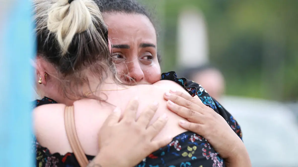 Women hug outside a pre-school after a 25-year-old man attacked children, killing several and injuring others, according to local police and hospital, in Blumenau, in the southern Brazilian state of Santa Catarina, Brazil April 5, 2023. REUTERS/Denner Ovidio NO RESALES. NO ARCHIVES