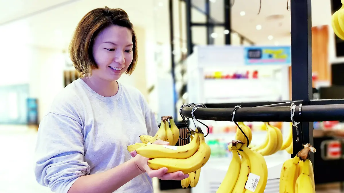 Frau kauft Bananen ein