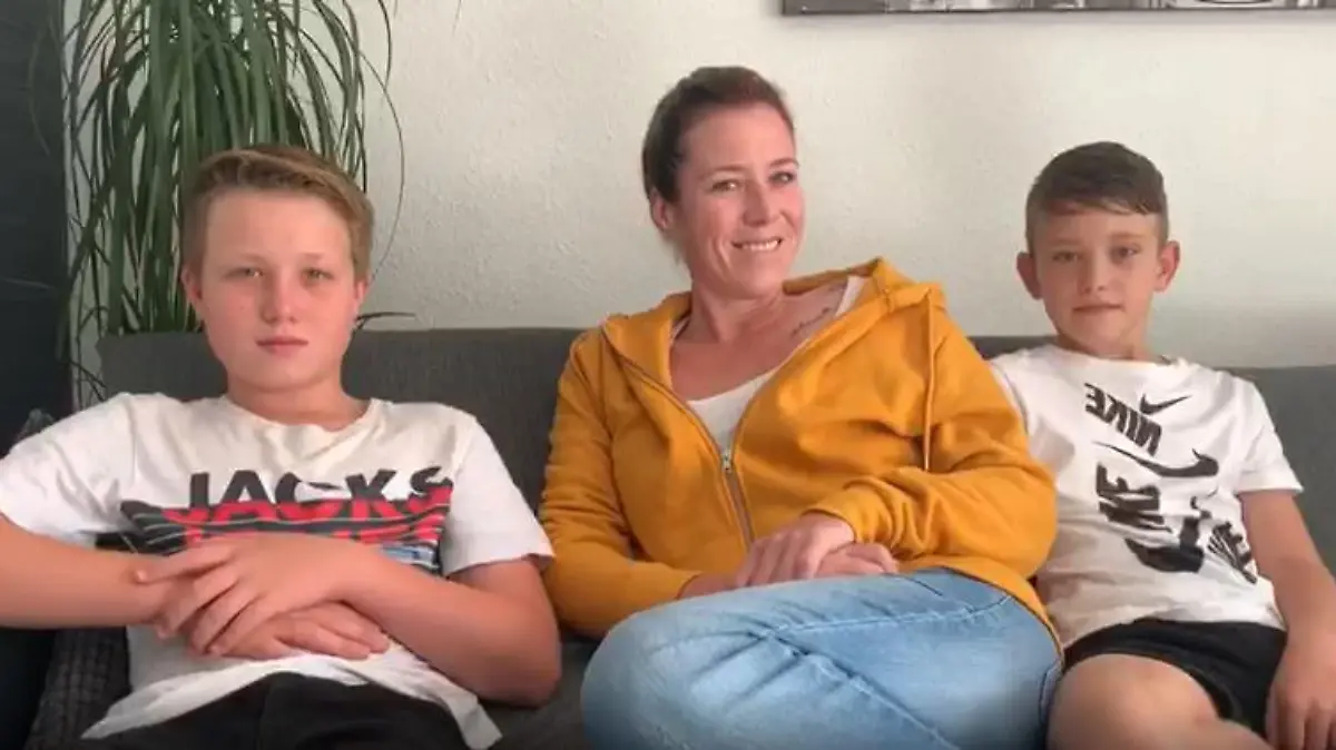 Frau sitzt mit zwei Jungs auf eienr Couch