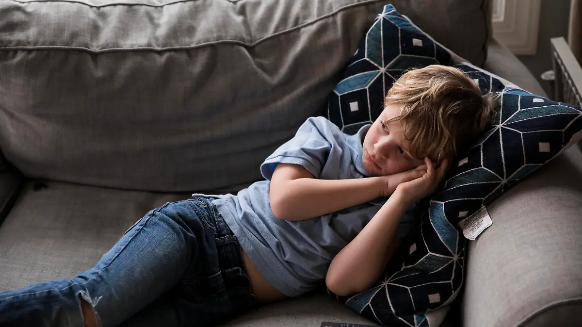 Sad Blonde Boy Watches TV While Laying on Couch Easton, MD, United States PUBLICATIONxINxGERxSUIxAUTxONLY CREMJA200506A-357519-01,model released, Symbolfoto