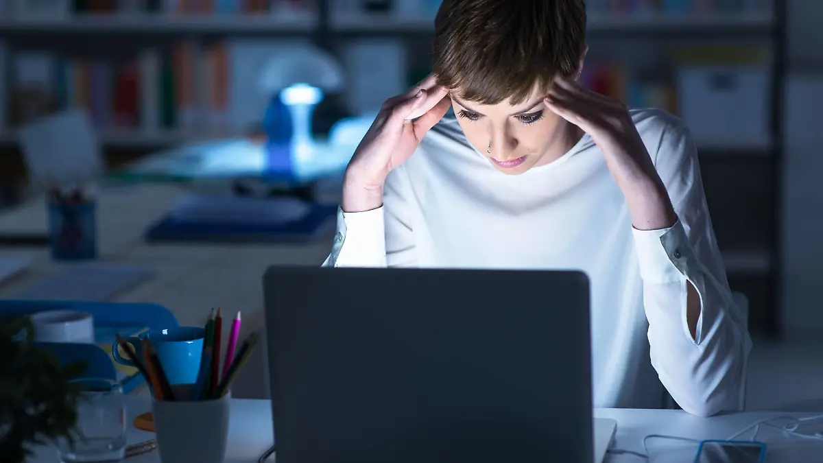 Frau sitzt abends vorm PC