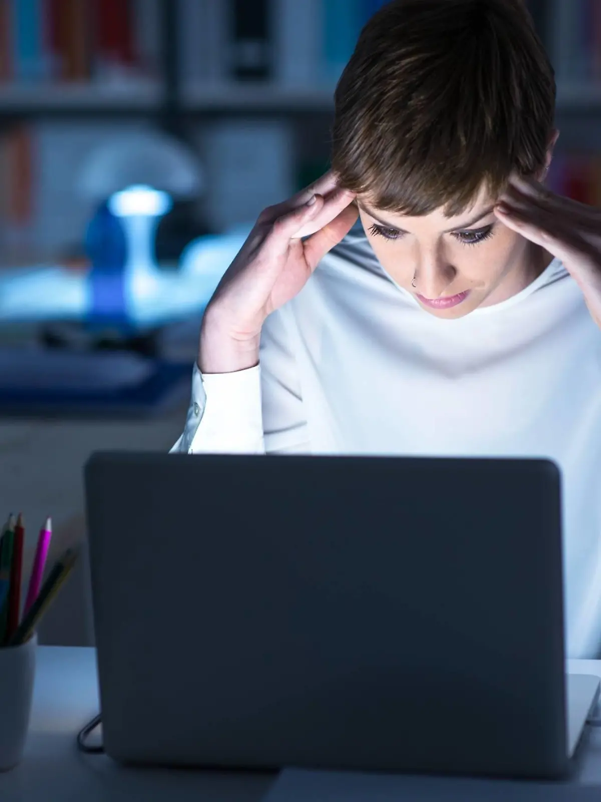 Frau sitzt abends vorm PC