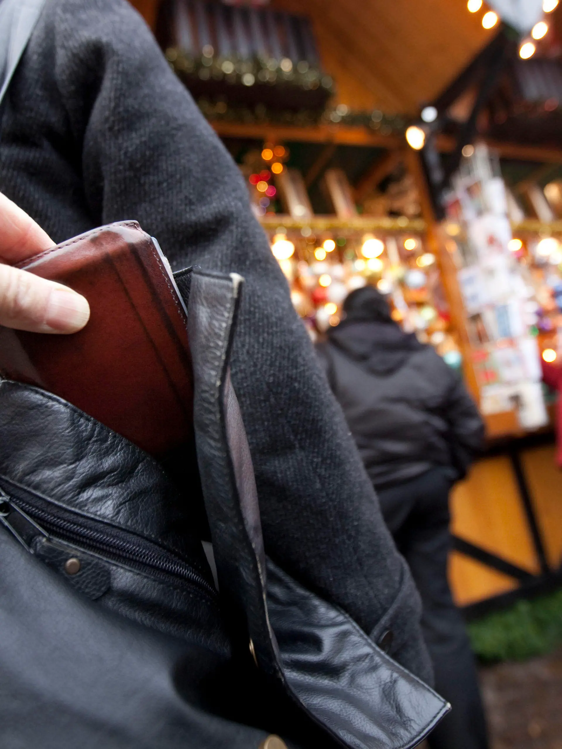 ARCHIV - ILLUSTRATION - Ein Mann zieht am 10.12.2009 auf dem Weihnachtsmarkt in Frankfurt am Main einer Besucherin die Geldbörse aus der Handtasche (gestelltes Bild - Illustration).  (zu dpa «Taschendiebe mögen Weihnachtsmärkte - Polizei warnt und gibt Tipps» vom 03.12.2016) +++(c) dpa - Bildfunk+++