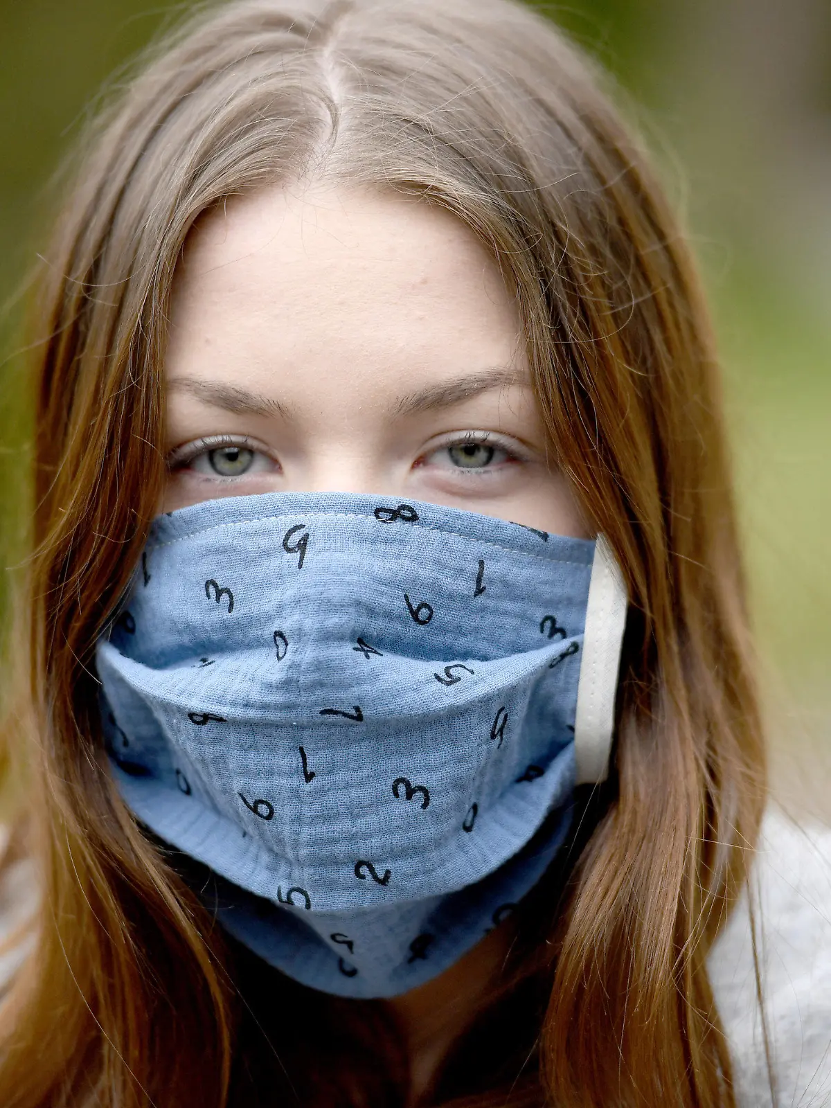 26.04.2020, Schleswig-Holstein, Aukrug: Eine Jugendliche trägt eine selbstgenähte Gesichtsmaske. Ab der kommenden Woche treten bundesweit Richtlinien zum Tragen von Gesichtsmasken zum Schutz vor der Ansteckung mit dem neuartigen Coronavirus in Kraft. Foto: Carsten Rehder/dpa +++ dpa-Bildfunk +++