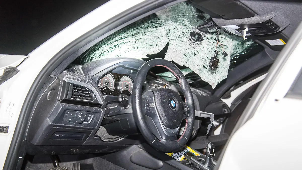 08.05.2018, Schleswig-Holstein, Harislee: Zersplittert hängt die Windschutzscheibe eines BMWs nach der Kollision mit einem großen Stein im Rahmen. Bei einem Steinwurf von einer Autobahnbrücke auf der A7 zwischen Flensburg und der dänischen Grenze war die Fahrerin des Wagens schwer verletzt worden. (zu dpa "Steinwurf auf der A7 in Schleswig-Holstein - Frau schwer verletzt" vom 09.05.2018) Foto: Benjamin Nolte/dpa +++ dpa-Bildfunk +++