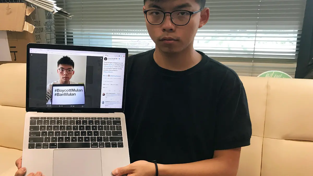 Pro-democracy activist Joshua Wong holds a laptop displaying his Twitter post which calls for a boycott of Disney's film "Mulan", as he poses for a photo in Hong Kong, China September 8, 2020. REUTERS/Aleksander Solum