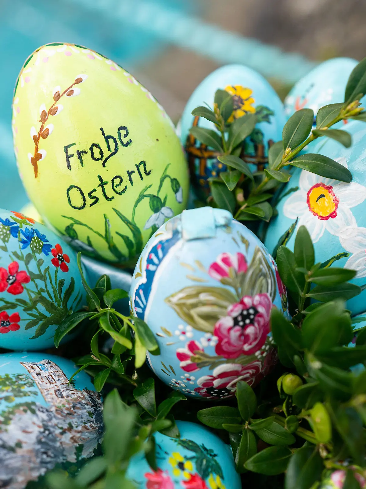 ARCHIV - 10.04.2022, Bayern, Egloffstein: Bemalte Ostereier sind an einer Girlande an einem Osterbrunnen angebracht. In der Fränkischen Schweiz werden Brunnen und andere Wasserstellen mit bemalten Eiern und Girlanden aus Tannenzweigen geschmückt. (zu dpa: «Die Osterbrunnen sind wieder frisch verziert») Foto: Nicolas Armer/dpa +++ dpa-Bildfunk +++