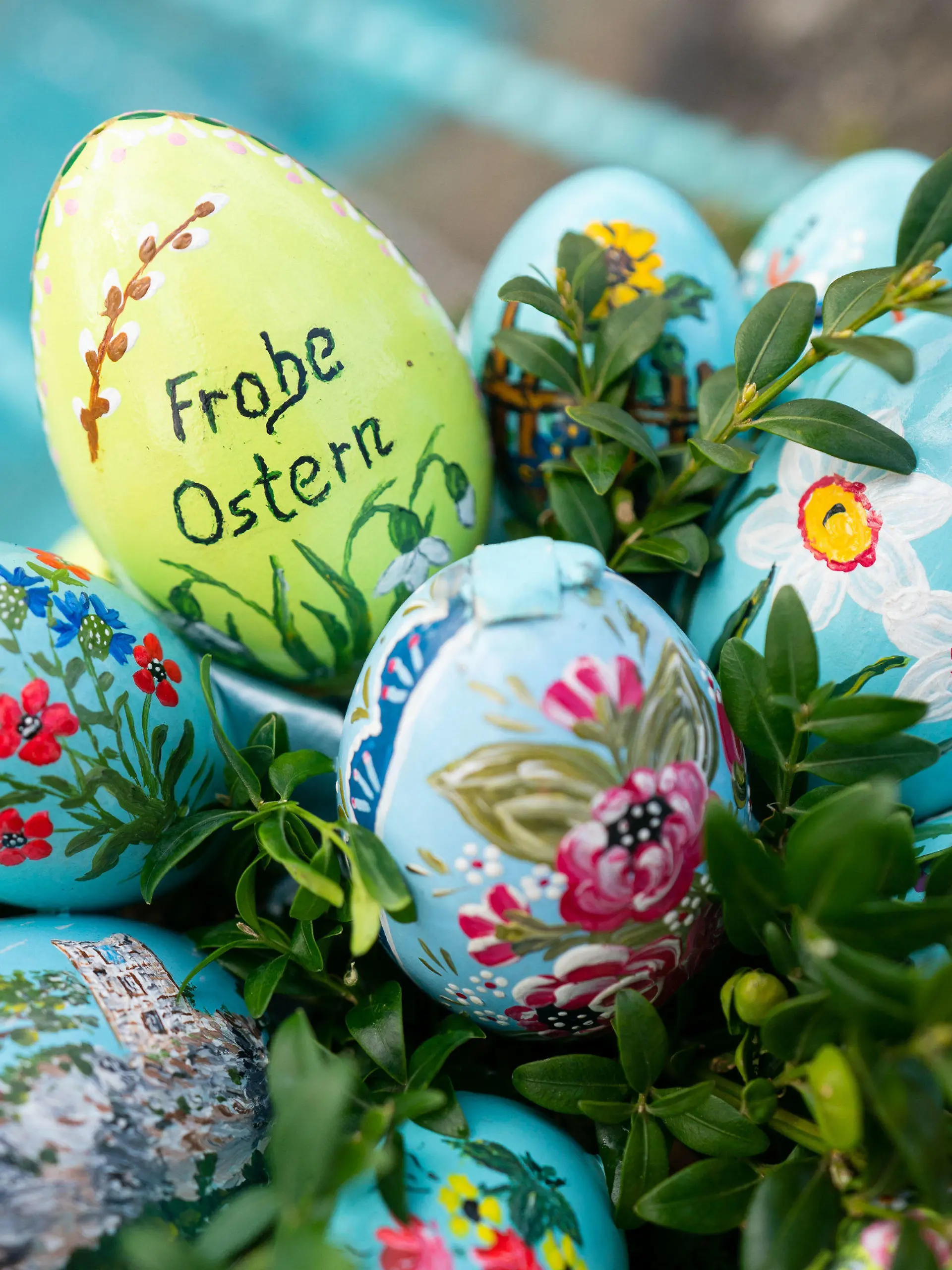 ARCHIV - 10.04.2022, Bayern, Egloffstein: Bemalte Ostereier sind an einer Girlande an einem Osterbrunnen angebracht. In der Fränkischen Schweiz werden Brunnen und andere Wasserstellen mit bemalten Eiern und Girlanden aus Tannenzweigen geschmückt. (zu dpa: «Die Osterbrunnen sind wieder frisch verziert») Foto: Nicolas Armer/dpa +++ dpa-Bildfunk +++