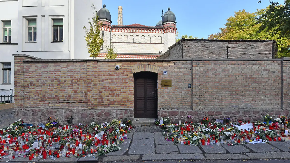 ARCHIV - 13.10.2019, Sachsen-Anhalt, Halle (Saale): Blumen und Kerzen stehen neben der Tür zur Synagoge, vier Tage nach dem rechtsextremistischen Anschlag auf die Gemeinde. (zu dpa "Verfassungsschutz sieht starke Verbreitung antisemitischer Hetze") Foto: Hendrik Schmidt/dpa-Zentralbild/dpa +++ dpa-Bildfunk +++