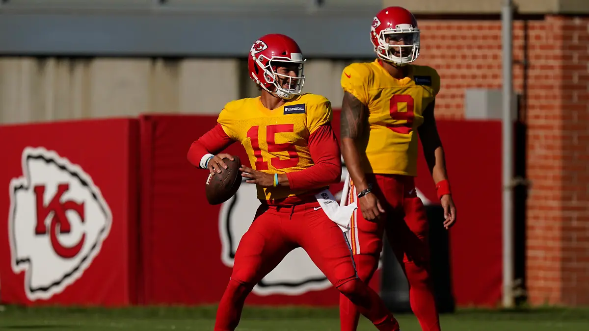 Kansas City Chiefs quarterback Patrick Mahomes throws while quarterback Jordan Ta'amu (9) watches during an NFL football training camp practice Thursday, Aug. 27, 2020, in Kansas City, Mo. (AP Photo/Charlie Riedel)