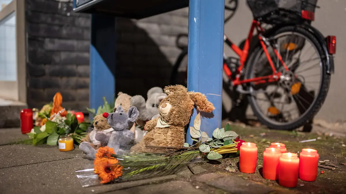 04.09.2020, Nordrhein-Westfalen, Solingen: Teddybären, Kerzen und Blumen liegen und stehen vor einem Haus. Eine 27-jährige Mutter soll in Solingen fünf Kinder umgebracht haben. Die Mutter habe sich danach im Düsseldorfer Hauptbahnhof auf die Gleise begeben, aber verletzt überlebt. Foto: Marcel Kusch/dpa +++ dpa-Bildfunk +++