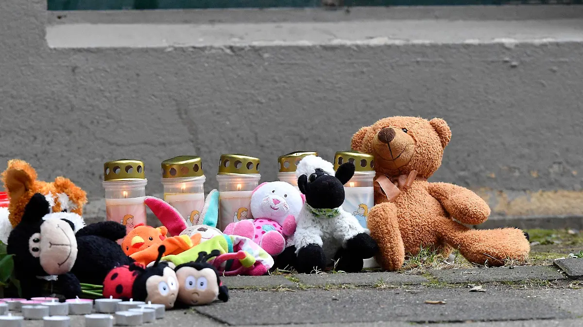 Teddy bears and candles are pictured in front of an apartment building where five dead children were found in Solingen, Germany, Friday, Sept. 4, 2020. Police say five young children have been found dead on Thursday at the apartment in Solingen, their mother is suspected of killing them. Police said the children's 27-year-old mother later jumped in front of a train in Duesseldorf and was taken to a hospital with injuries. Only one child of the mother survived, who was send to his grandmother before. (AP Photo/Martin Meissner)