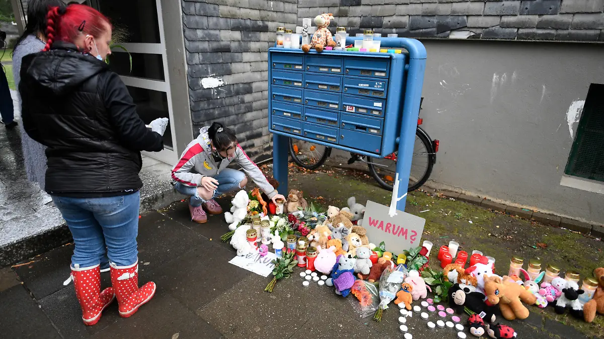 04.09.2020, Nordrhein-Westfalen, Solingen: Eine Frau legt zum Gedenken an die toten Kinder Blumen und Kerzen an einem Briefkasten ab. In einer Wohnung des Hauses wurden fünf tote Kinder gefunden. Ihre Mutter soll sie getötet und dann einen Suizidversuch unternommen haben. Foto: Roberto Pfeil/dpa - ACHTUNG: Namenschilder auf dem Briefkasten wurden aus persönlichkeitsrechtlichen Gründen gepixelt. +++ dpa-Bildfunk +++