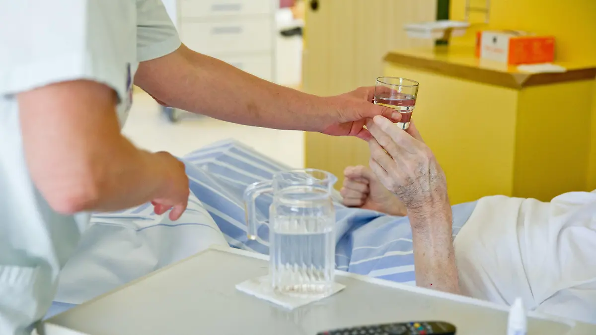 ARCHIV - 01.07.2015, Bayern, Nürnberg: Eine Krankenpflegerin reicht einem Patienten in der Onkologie im Klinikum Nürnberg ein Glas Wasser. (Zu dpa «Für mehr Fachkräfte: Regierung will Pflege-Ausbildung ankurbeln» vom 25.01.2019) Foto: Daniel Karmann/dpa +++ dpa-Bildfunk +++