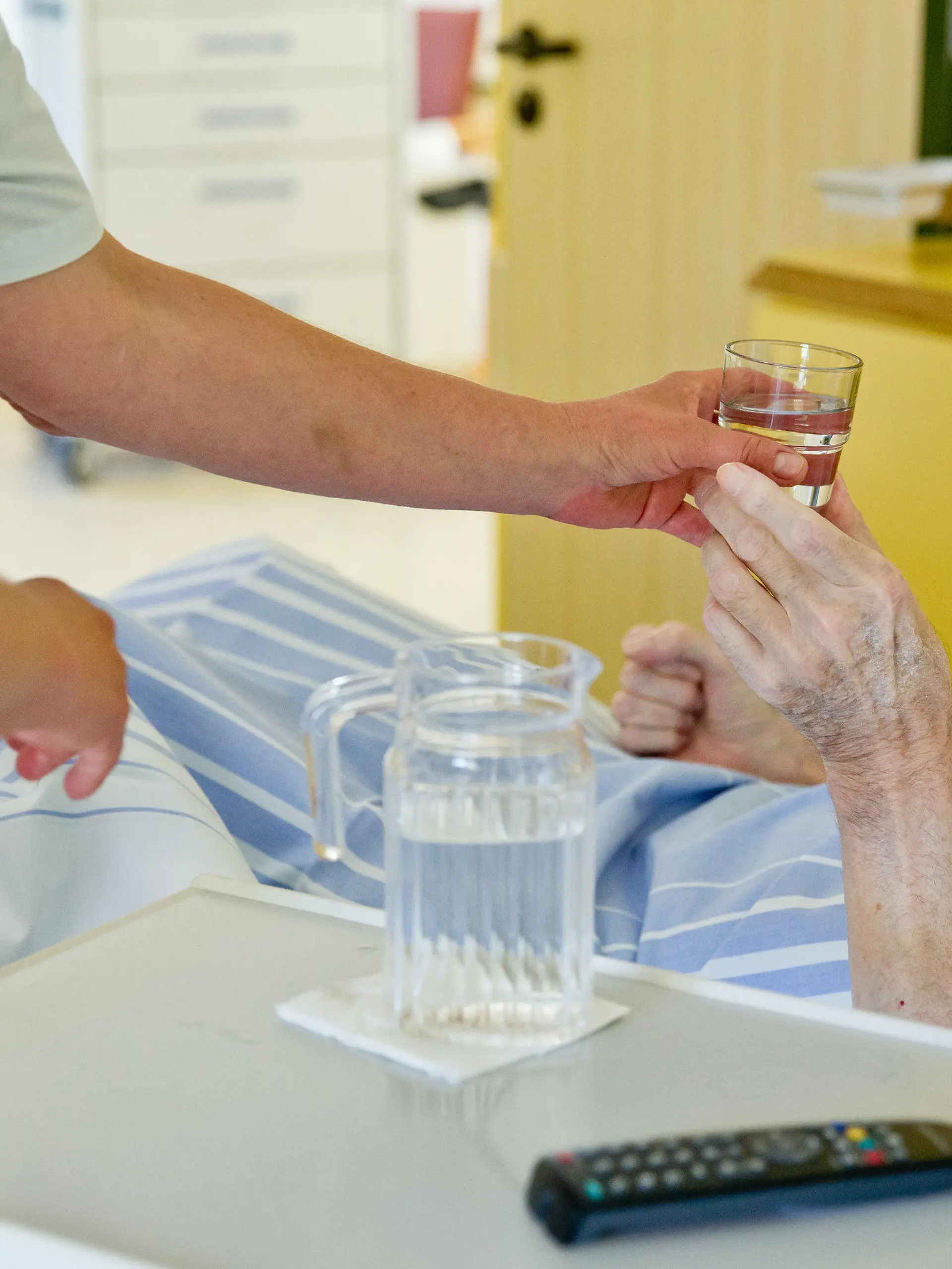 ARCHIV - 01.07.2015, Bayern, Nürnberg: Eine Krankenpflegerin reicht einem Patienten in der Onkologie im Klinikum Nürnberg ein Glas Wasser. (Zu dpa «Für mehr Fachkräfte: Regierung will Pflege-Ausbildung ankurbeln» vom 25.01.2019) Foto: Daniel Karmann/dpa +++ dpa-Bildfunk +++