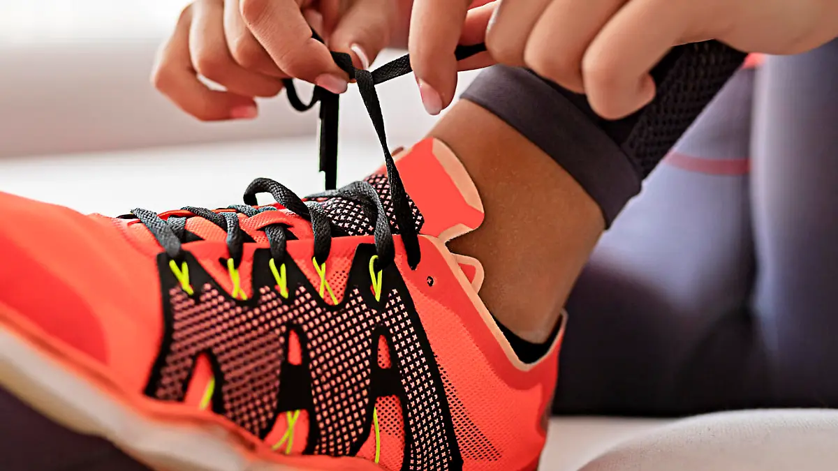 Frau zieht sich Sneakers an