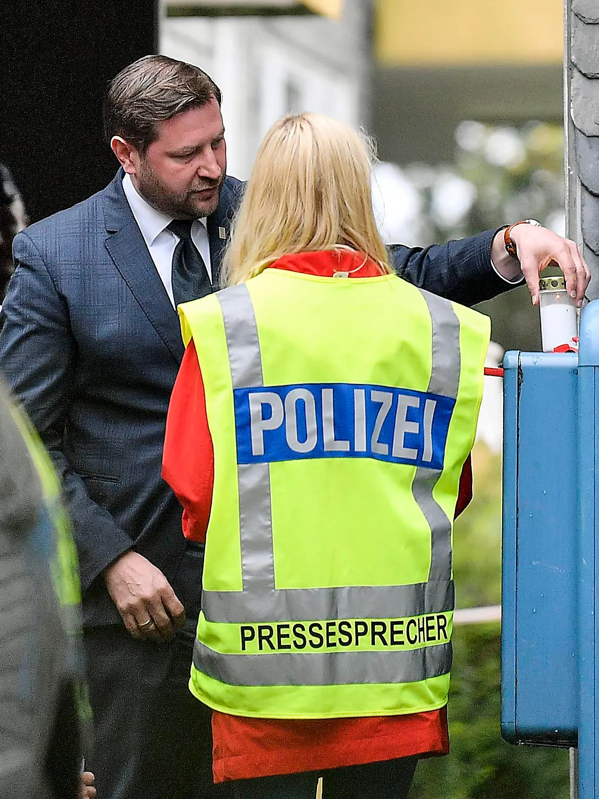 Solingen's mayor Tim Kurzbach puts a candle at the entrance of the house, where five dead children were found in Solingen, Germany, Thursday, Sept. 3, 2020. Police say five children have been found dead at an apartment in a western German city, and their mother is suspected of killing them. The bodies of three girls and two boys were found in Solingen, near Cologne and Duesseldorf on Thursday. (AP Photo/Martin Meissner)