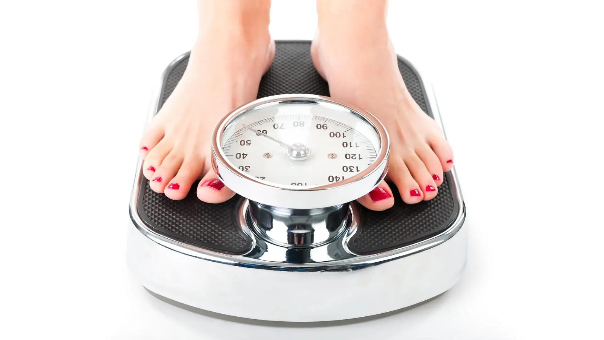 Diet and weight, young woman standing on a scale, only feet to be seen