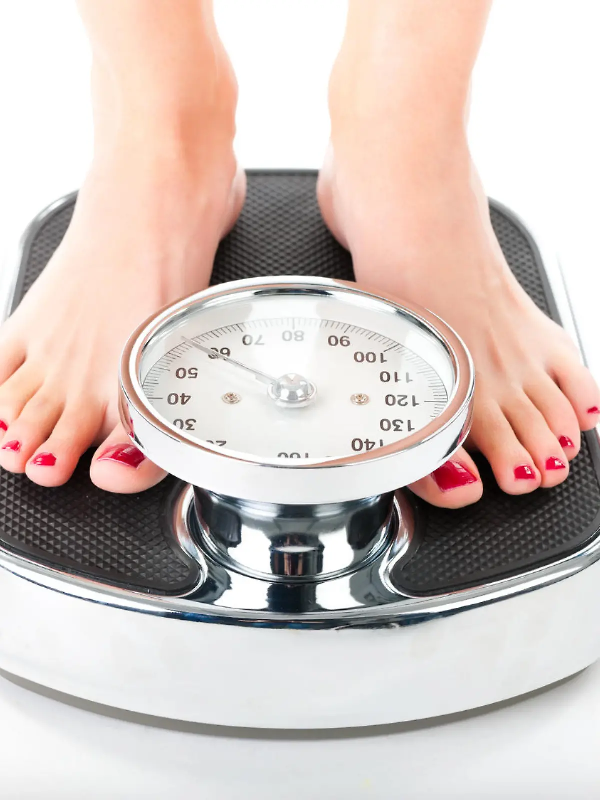 Diet and weight, young woman standing on a scale, only feet to be seen