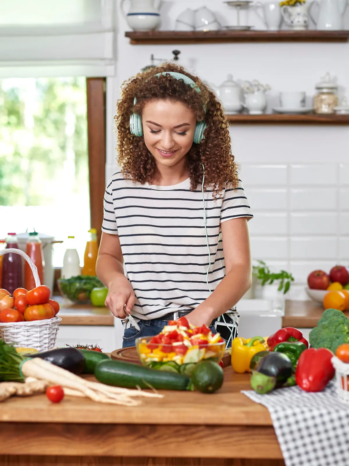 Frau hört beim Kochen Musik