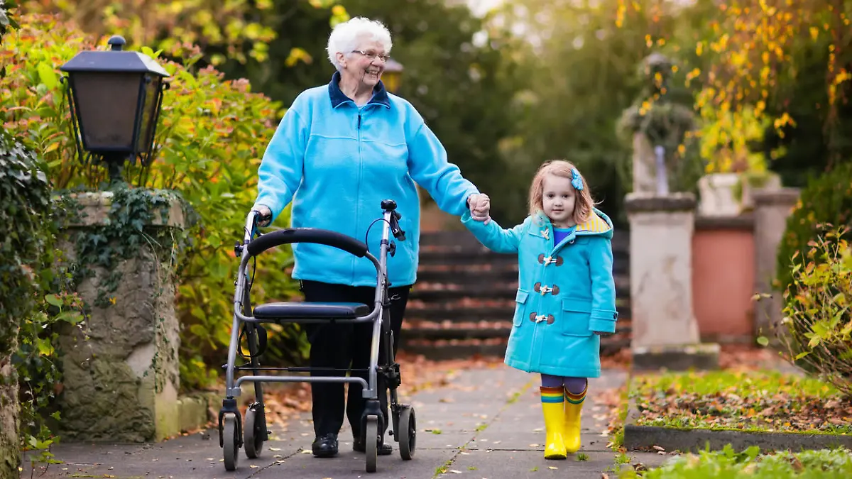 Ältere Dame mit Rollator und Enkelin